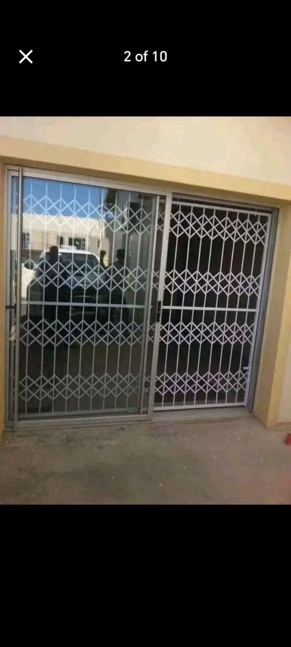 White retractable trellis security gate on a sliding glass door