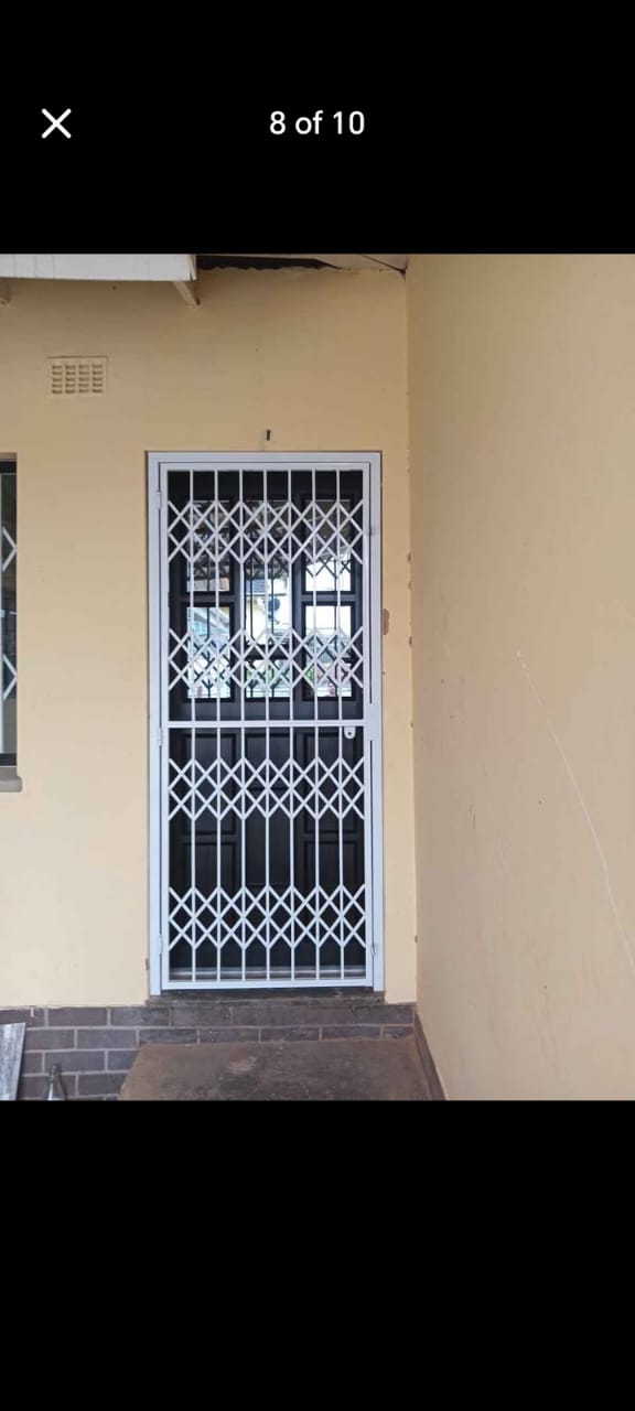 White trellis security gate installed over a residential front door
